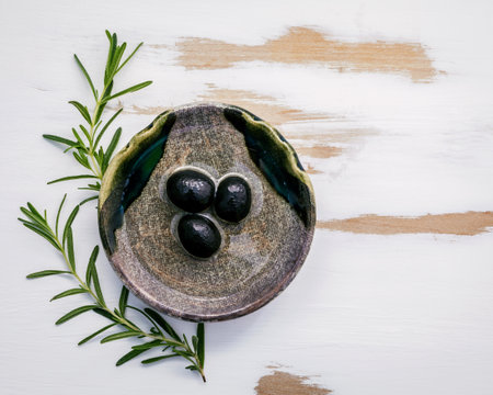 Bowl of extra virgin olive oil with rosemary. Sprigs of rosemary and olive oil set up on white shabby wooden background . Fresh branch of rosemary with bowl of olive oil with flat lay .の写真素材