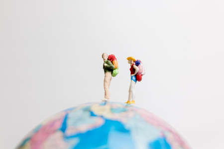 Miniature people figure standing on the globe world mapの写真素材
