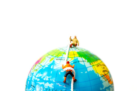 Miniature people: Hikers climbing up on the Globe . Sport and leisure concept.の写真素材