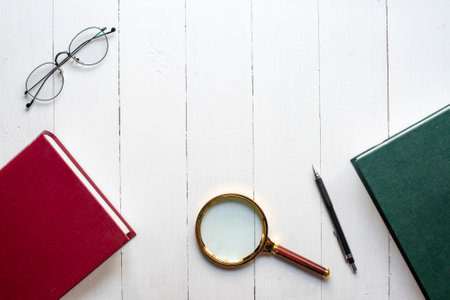 Education concept, book ,pen, eyeglasses, magnifying glass on white wood backgroundの写真素材
