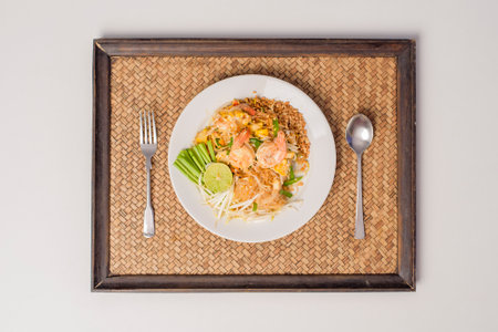 Top view of Thai traditional food Pad Thai Noodles with shrimp in dish on wooden table