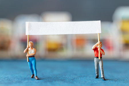 Miniature people, protesters holding signs, raising their hands for revolution or protesting Concept