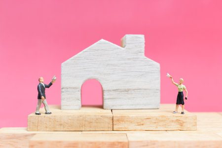Miniature people : Couple with house on pink background , Valentine's day conceptの写真素材