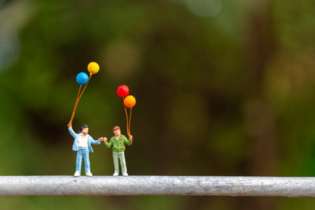 Miniature people : Happy family holding colorful balloons , Happy family Concept