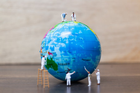 Miniature people : Painters are painting The globe on wooden background , Save Earth concept