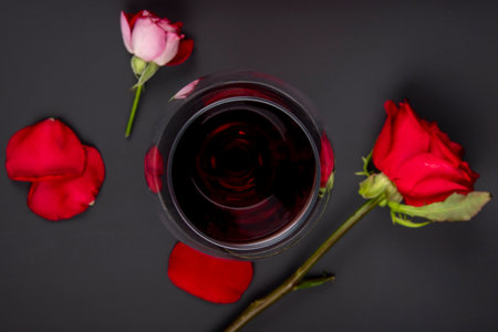 top view of a glass of wine with red color roses on black backgroundの写真素材