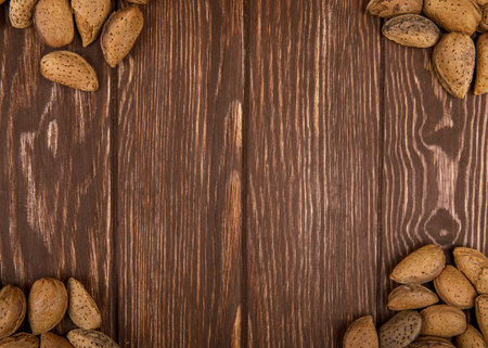 top view of almonds in shell scattered on wooden background with copy spaceの写真素材