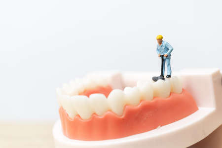 Miniature people : Worker team repairing a tooth