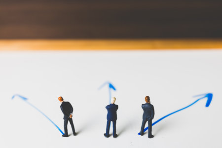 Miniature Businessman standing on arrow pathway , Business decision concept.の写真素材