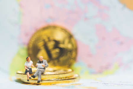 Miniature people: Businessman on stack of coins , business success concept.