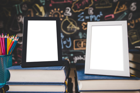 black photo frame and white photo frame on books and colored pencils in classroom