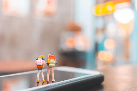 Miniature backpacker , Tourist people standing on smartphone , Travel conceptの写真素材