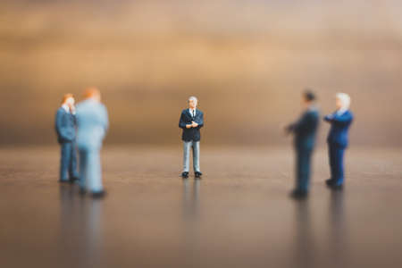 Miniature people businessman on wooden backgroundの写真素材