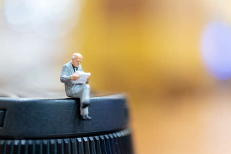 Miniature people : businessman and woman sitting on chairの写真素材