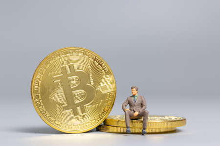Miniature people Businessman sitting on Bitcoin coinsの写真素材