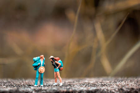 Miniature Backpacker standing on the concrete wall with natural background