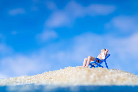 Miniature people sunbathing on The beach , Summer time conceptの写真素材