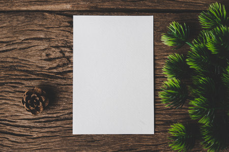 A blank card is placed on envelope and leaf with wood background