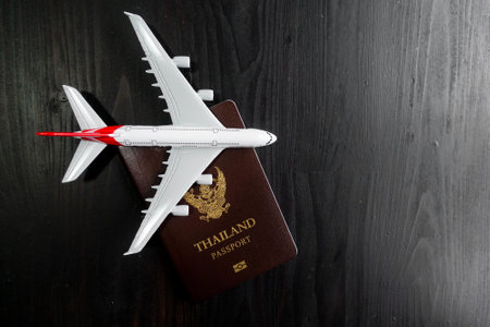 Airplane model and passport on wooden desk, ready travel concept