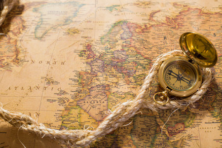 old compass and rope on vintage map