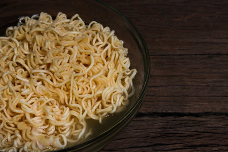 Instant noodles in bowl on wooden background.の写真素材