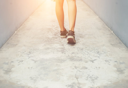 hipster cool woman feet with black sneakers walking on street.の写真素材