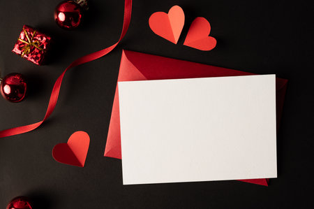White paper and red heart paper pasted on a black background.