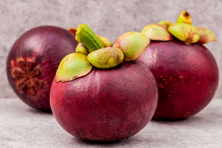 Delicious mangosteen fruit arranged on stone background.Mangosteen the queen of thai fruits.