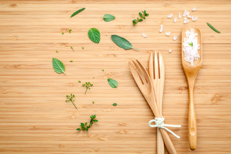 Aromatic herbs and spices green mint ,fennel ,oregano, sage,lemon thyme and peppermint with fork and sea salt on bamboo cutting board.の写真素材