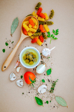 Italian food concept pasta with vegetables olive oil flavored with spices herb rosemary ,thyme,parsley and champignon mushroom set up with brown background.の写真素材