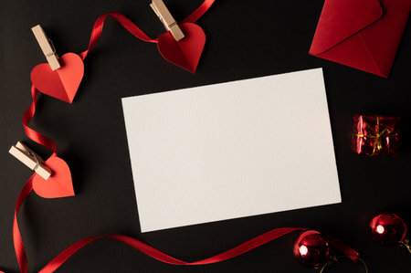 White paper and red heart paper pasted on a black background.の写真素材