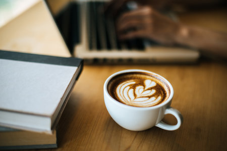 Latte art in coffee cup on the cafe tableの写真素材