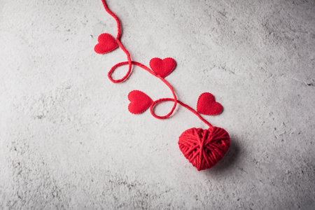 Red yarn heart shaped on the wall background