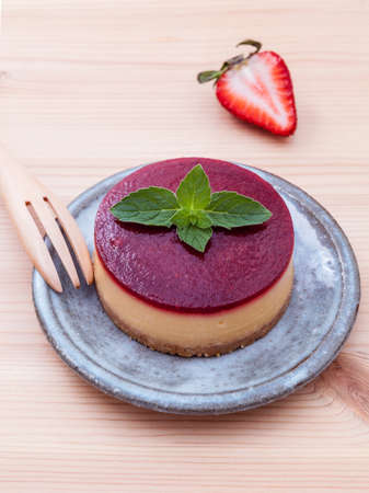 Strawberry cheesecake with fresh mint leaves on wooden background. Selective focus depth of field.の写真素材