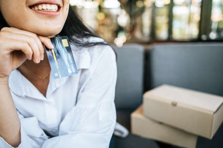 smile woman holding credit card in restaurantの写真素材