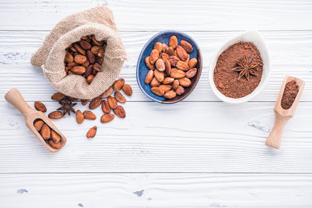 Cocoa powder and cacao beans on wooden background. Dark chocolate pieces crushed and aromatic herbs .の写真素材