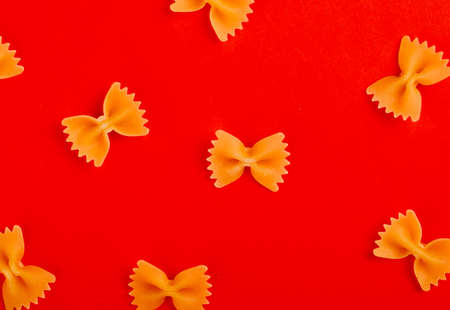 top view of pattern of farfalle pasta on red backgroundの写真素材