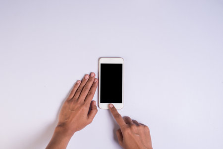 top view hand holding cell phone on white background