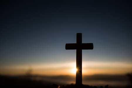 Silhouette of catholic cross and sunriseの写真素材