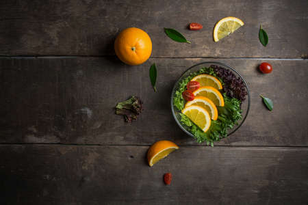 Fresh salad with slice of orange on a wooden backgroundの写真素材