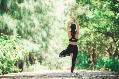 Young asian woman doing yoga in the morning at the park. Healthy lifestyle concept.の写真素材
