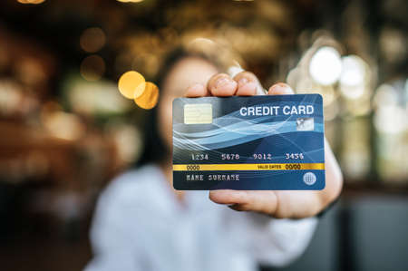 woman holding credit card in restaurantの写真素材
