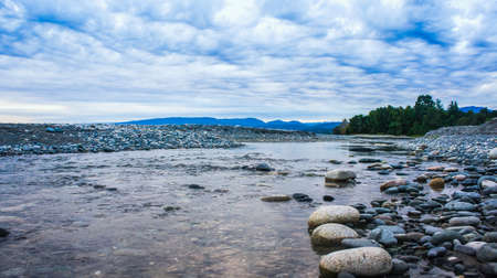 Landscape with a river and a rocky shore against the background of mountains in Abkhaziaの写真素材