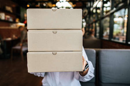 Woman holding a parcel box in cafeの写真素材