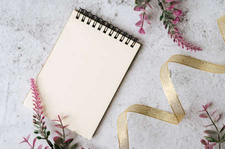notebook, ribbon and flower is placed on white backgroundの写真素材
