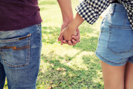 Young couple in love holding hands walking in the park.