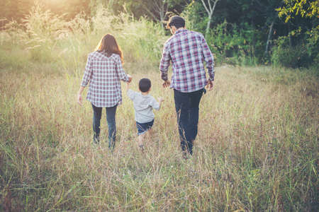 Rear of young family spending good time together. Family outdoors in love. Family value concept.の写真素材