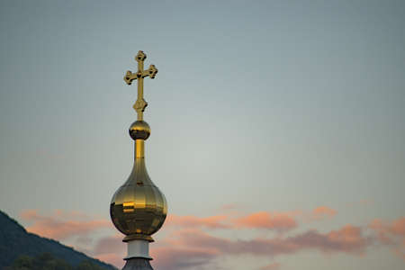The golden dome of the chapel against the background of the evening sky.