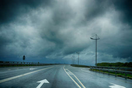 Wet road markings under a dark stormy sky in the Kaliningrad region
