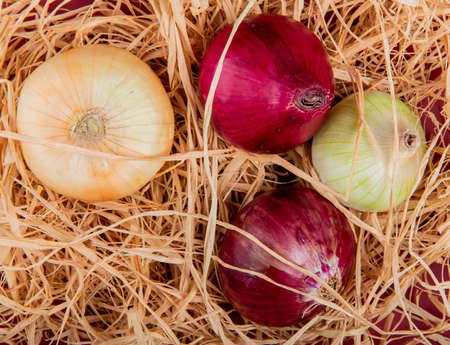 top view of sweet, red and white onions on straw backgroundの写真素材